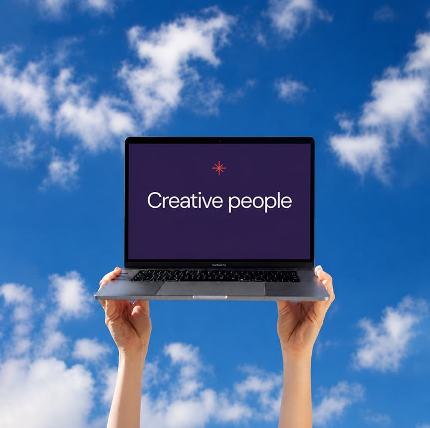 Persona sosteniendo una laptop con la leyenda Creative people